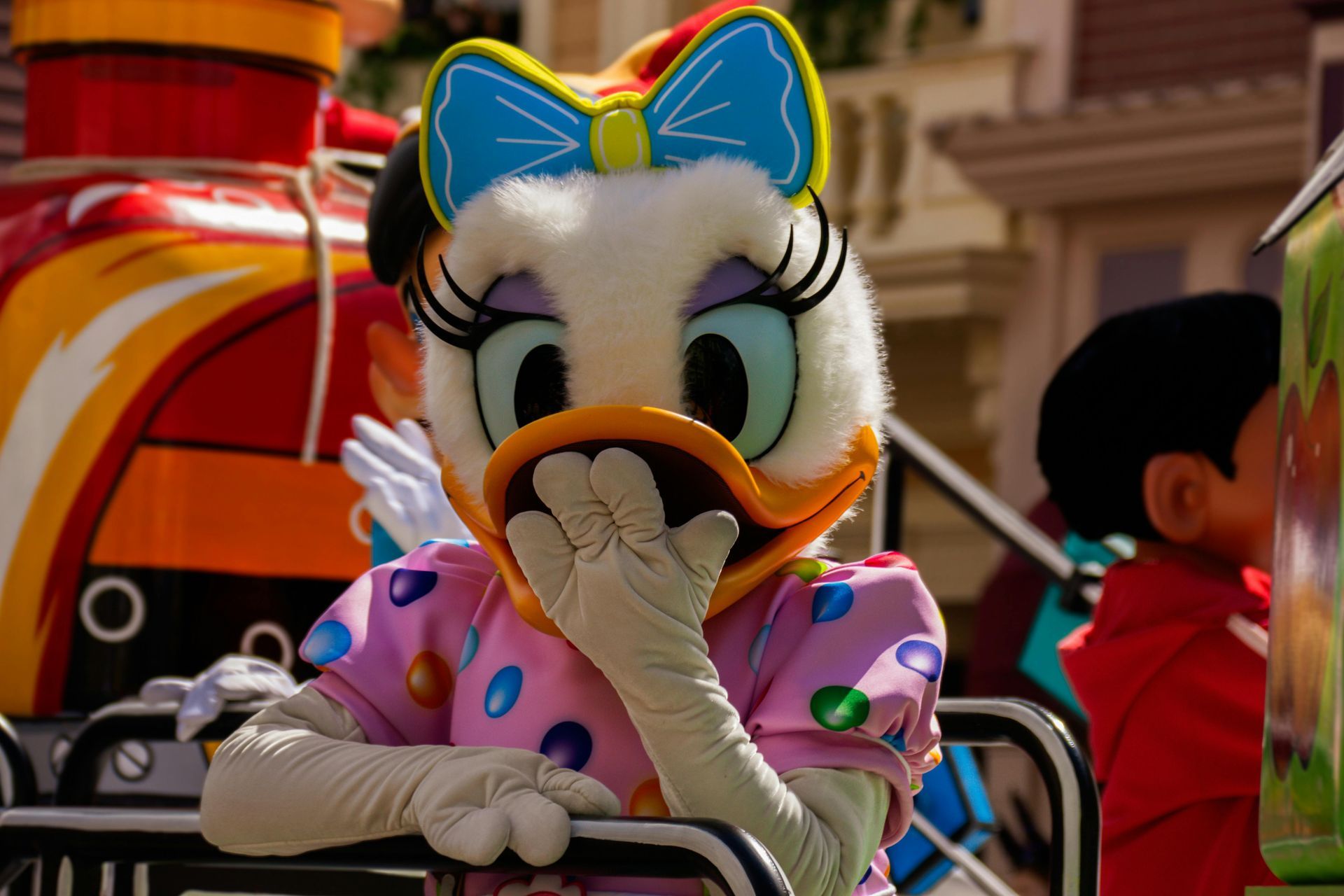 A daisy duck mascot is covering her mouth with her hand