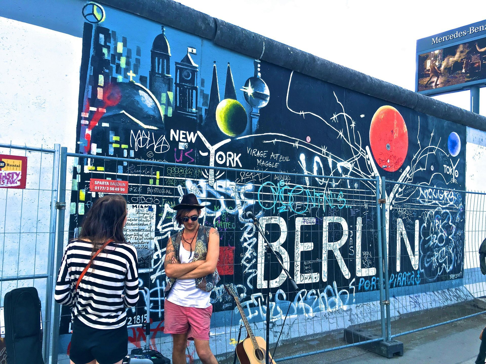 Two people are standing in front of a wall that says berlin