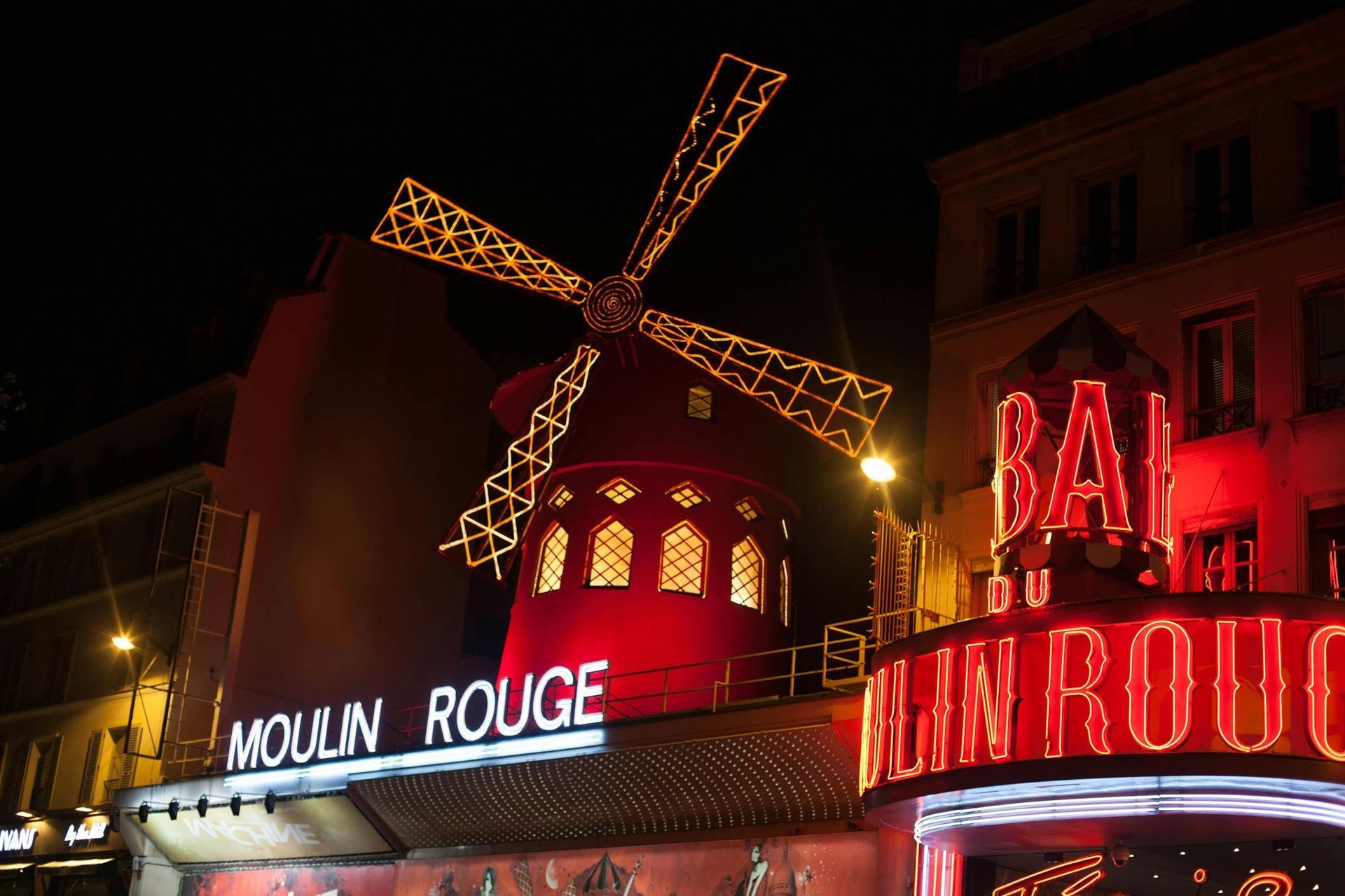 A moulin rouge sign is lit up at night