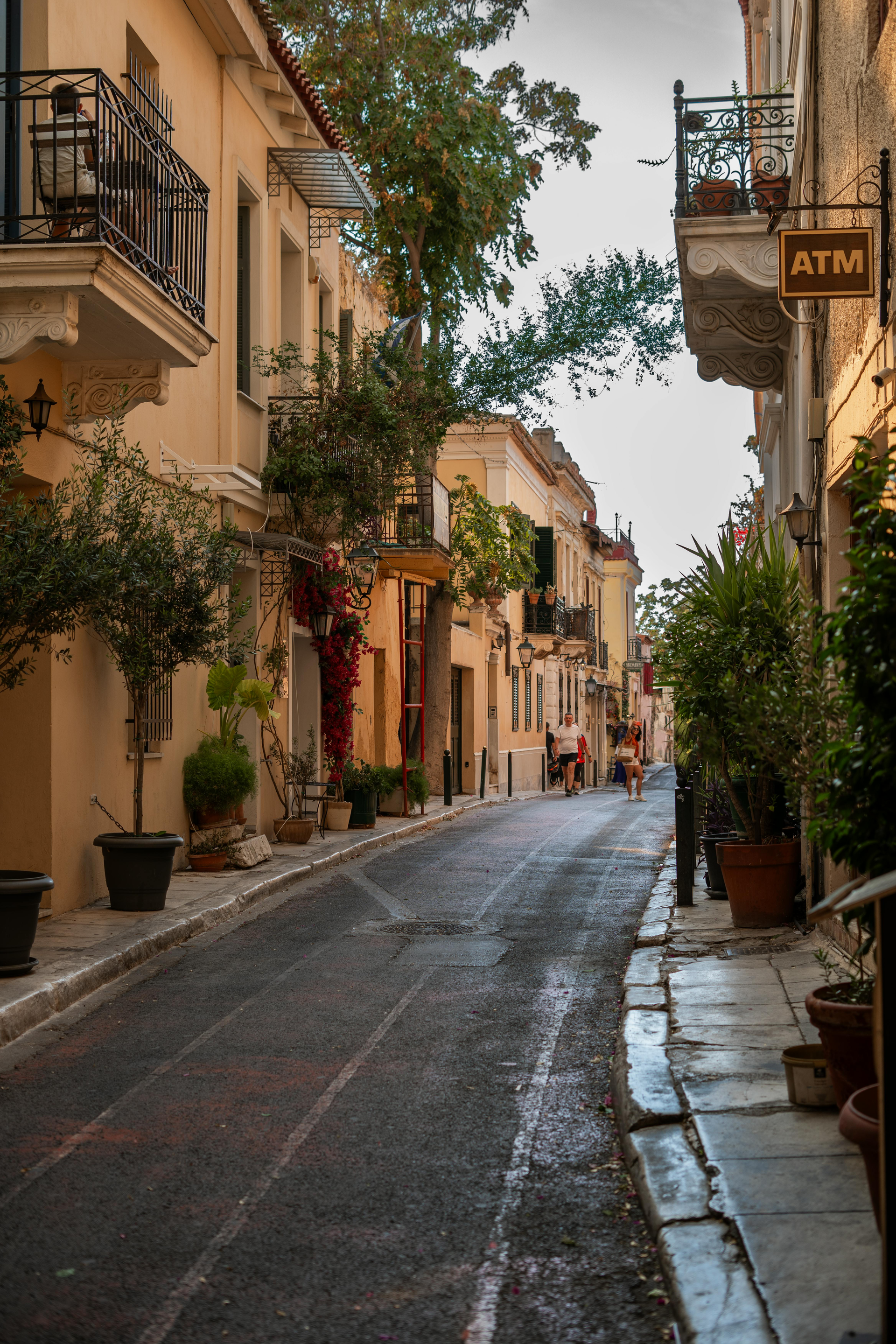 A narrow street with a sign that says atm on it