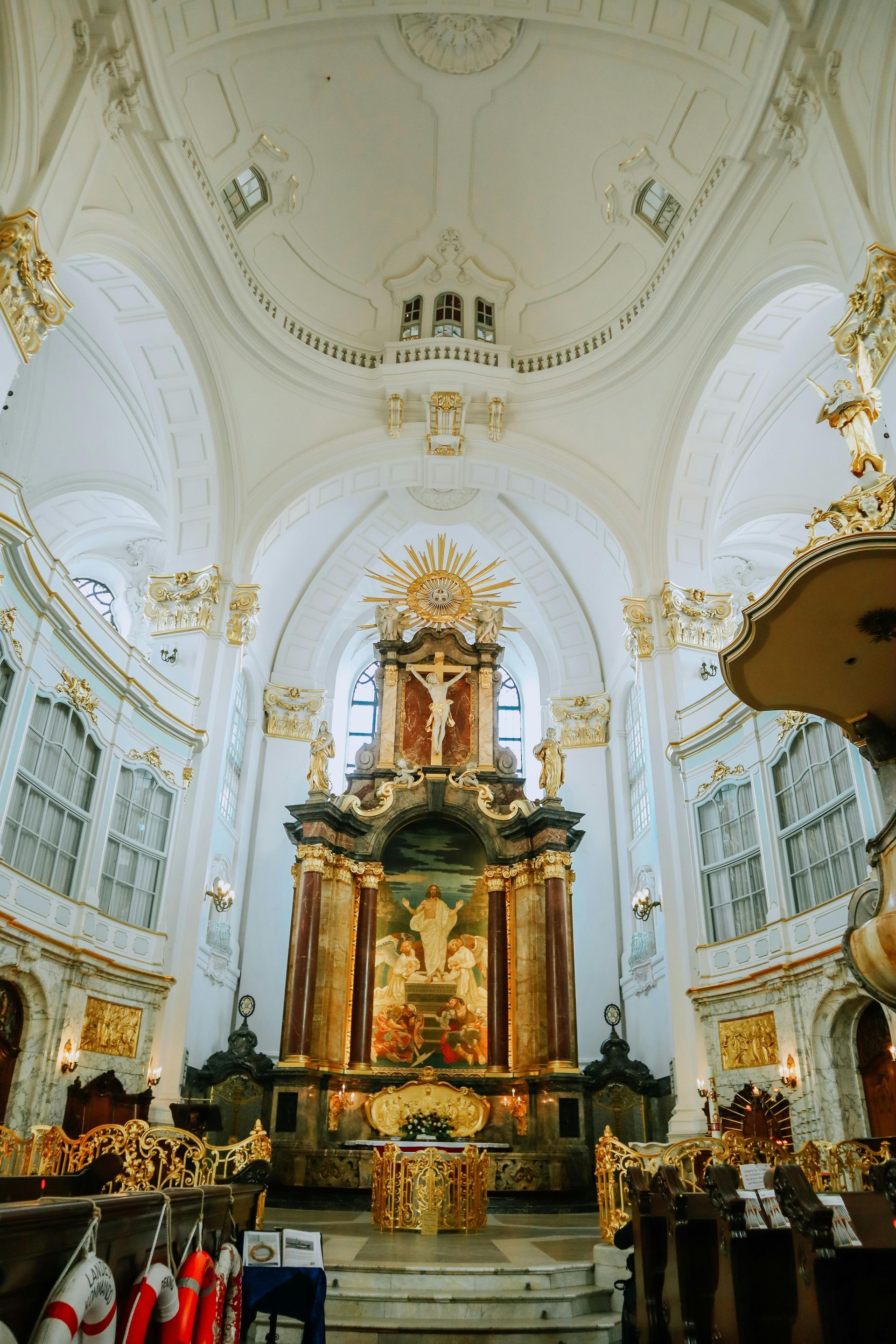 The inside of a church with a large altar and a cross.