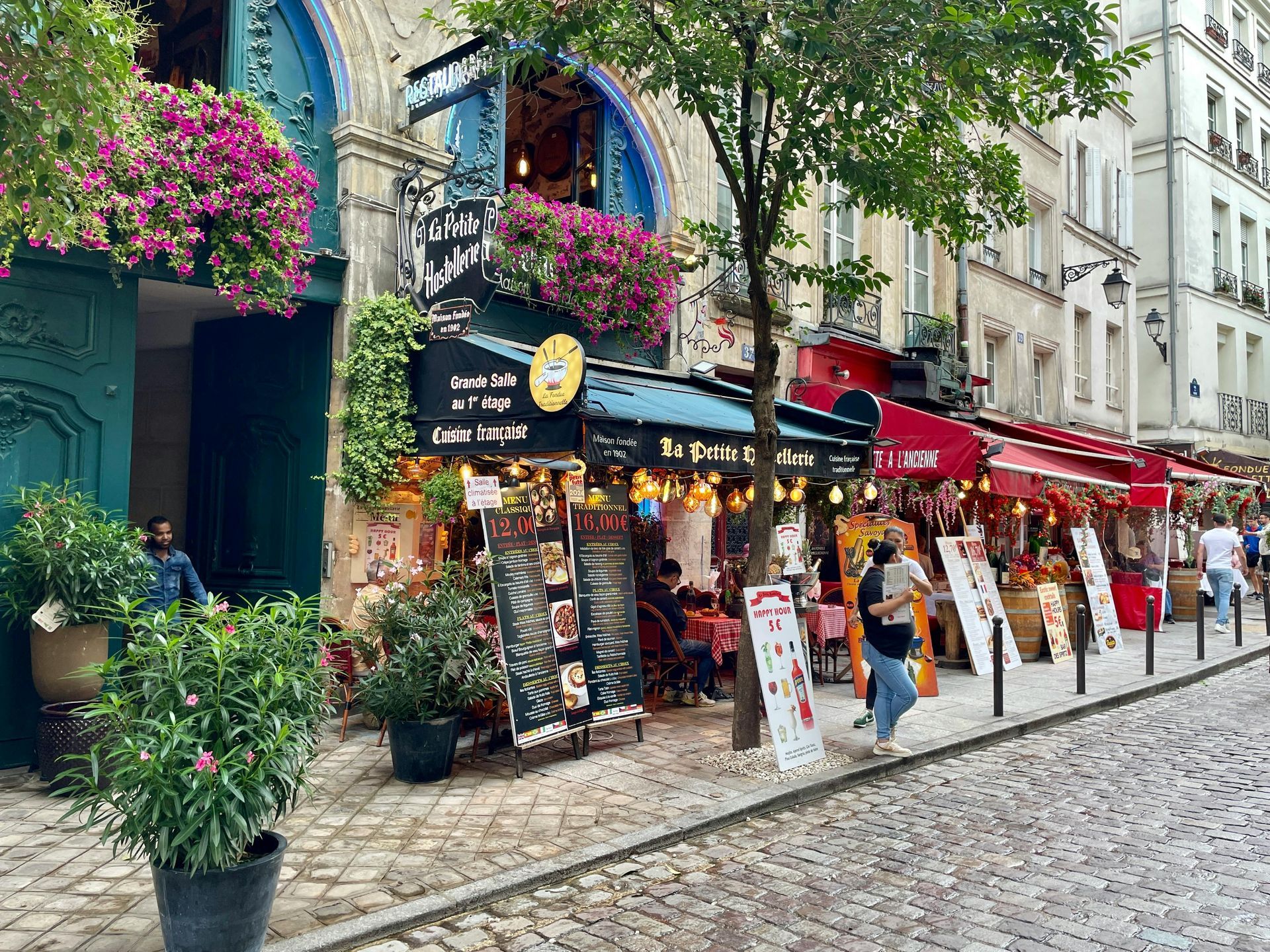 A row of shops on a cobblestone street in a city.