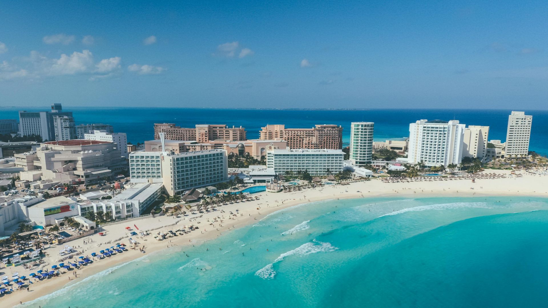 An aerial view of a beach with a city in the background.