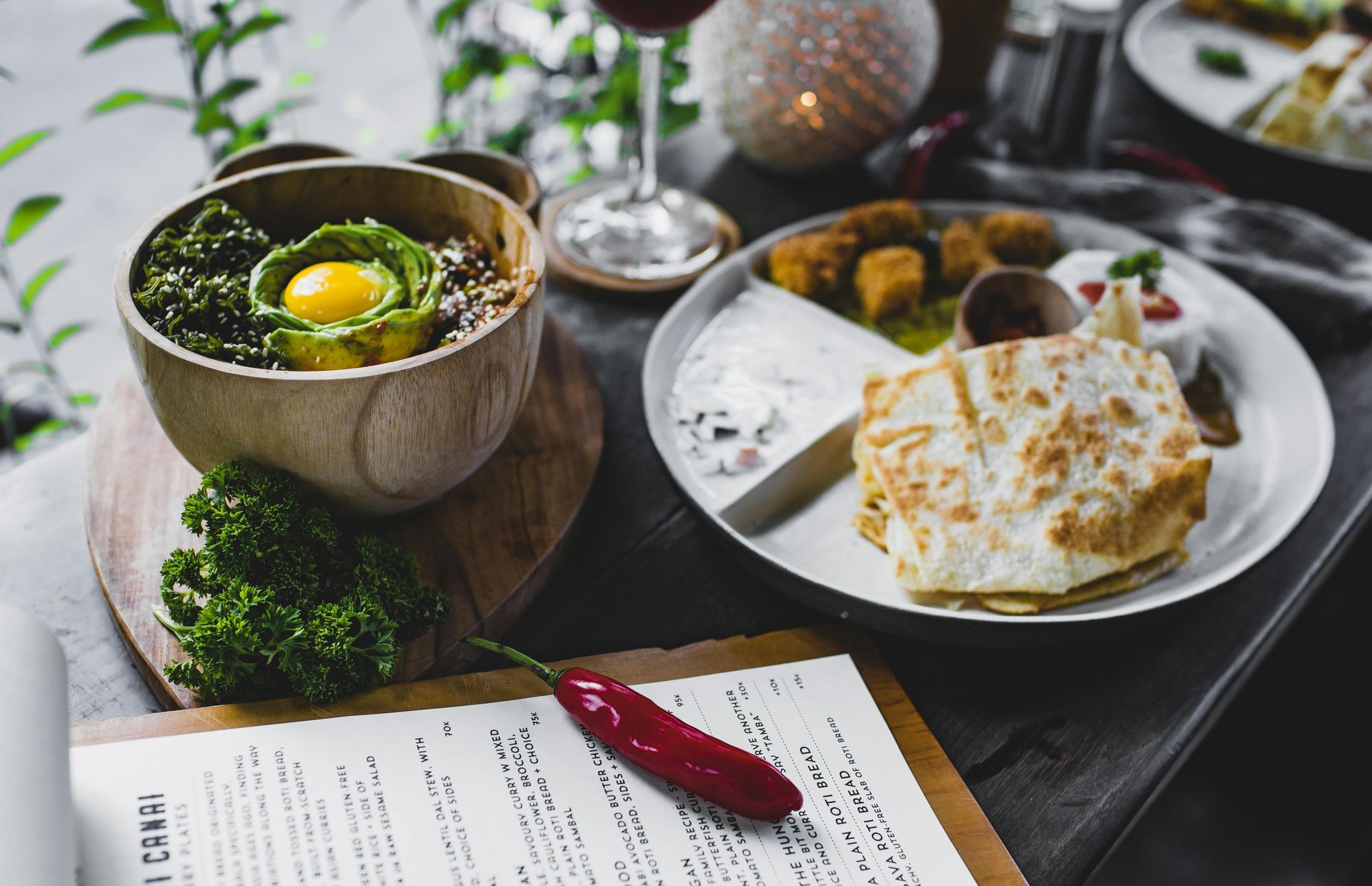 A table topped with plates of food and a menu.