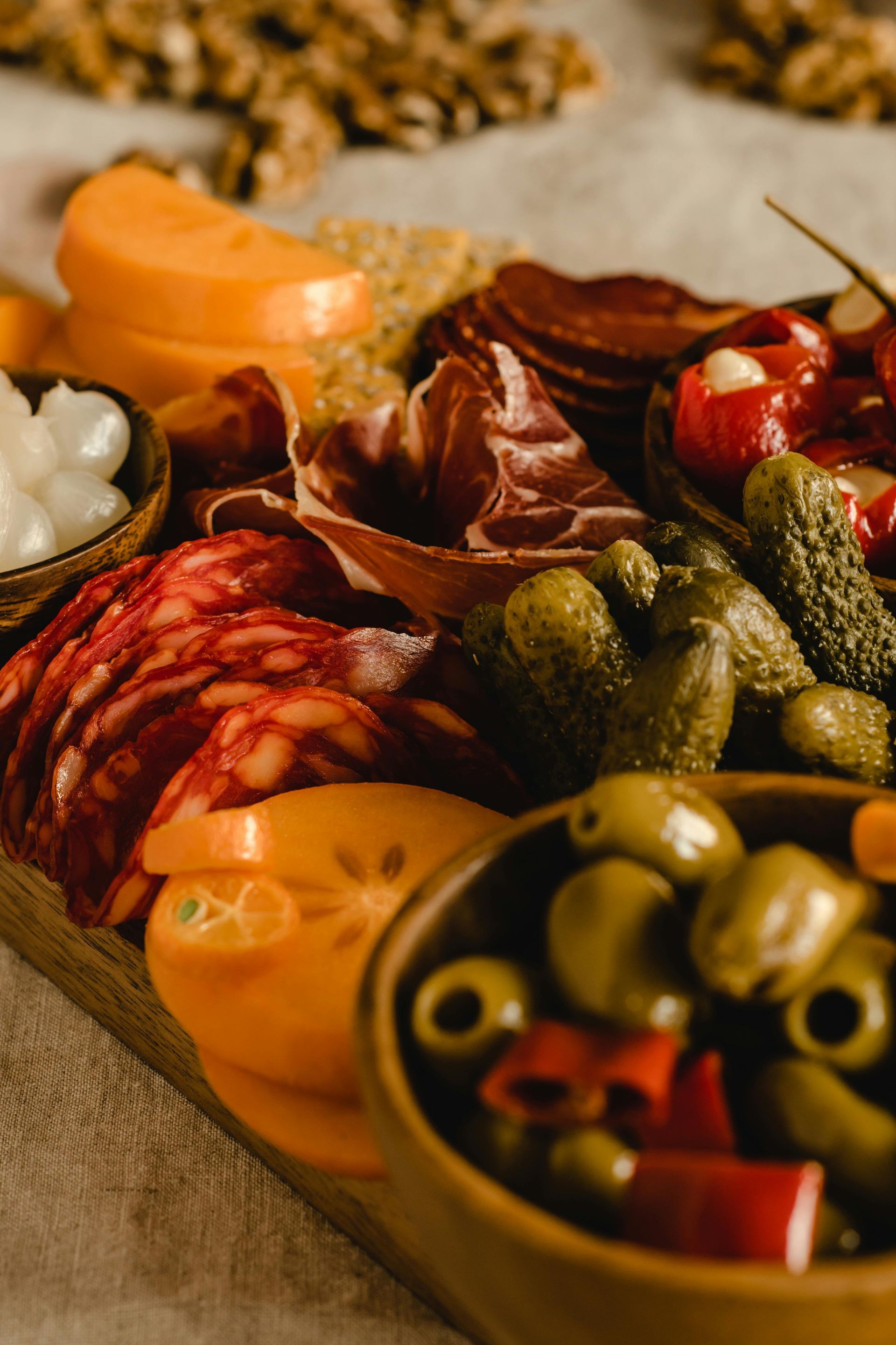 A wooden cutting board topped with a variety of meats and vegetables.