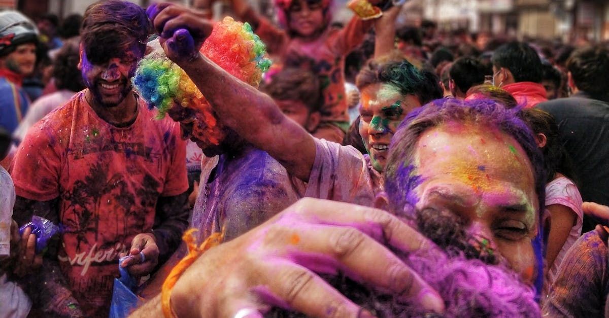 A man is being covered in purple powder at a holi festival.