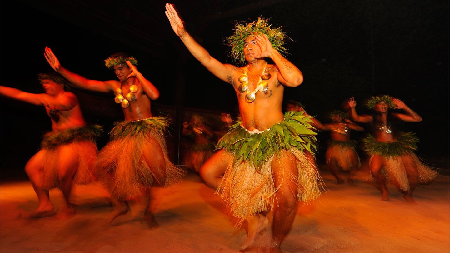 A group of people are dancing in a dark room.