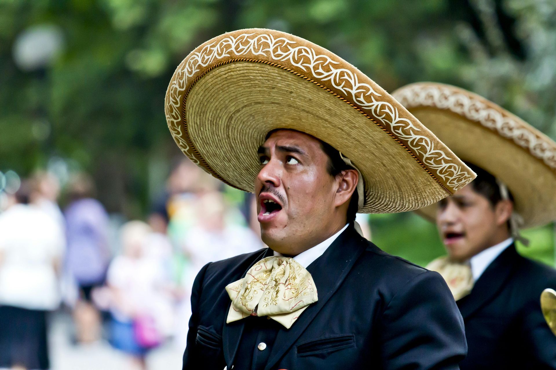 A man wearing a mariachi outfit and sombrero is making a funny face.
