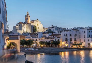 A small town with a church in the background and a body of water in the foreground.