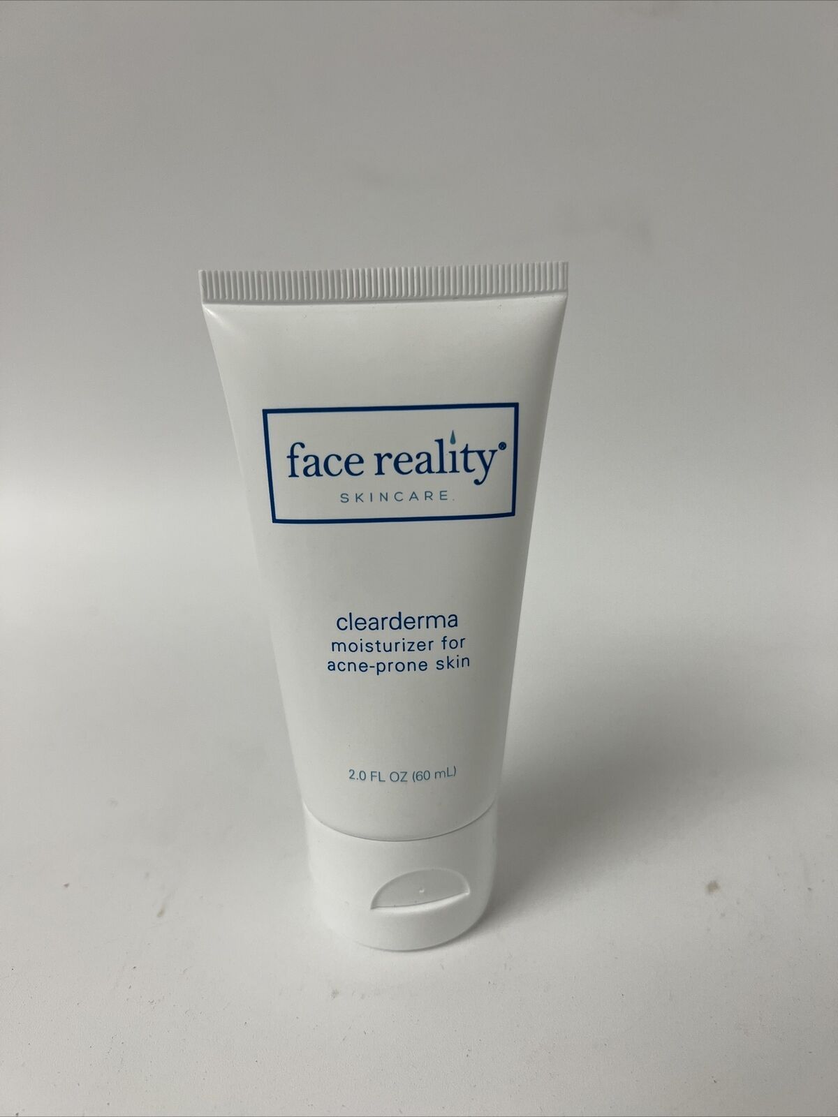 a tube of face reality lotion is sitting on a white surface