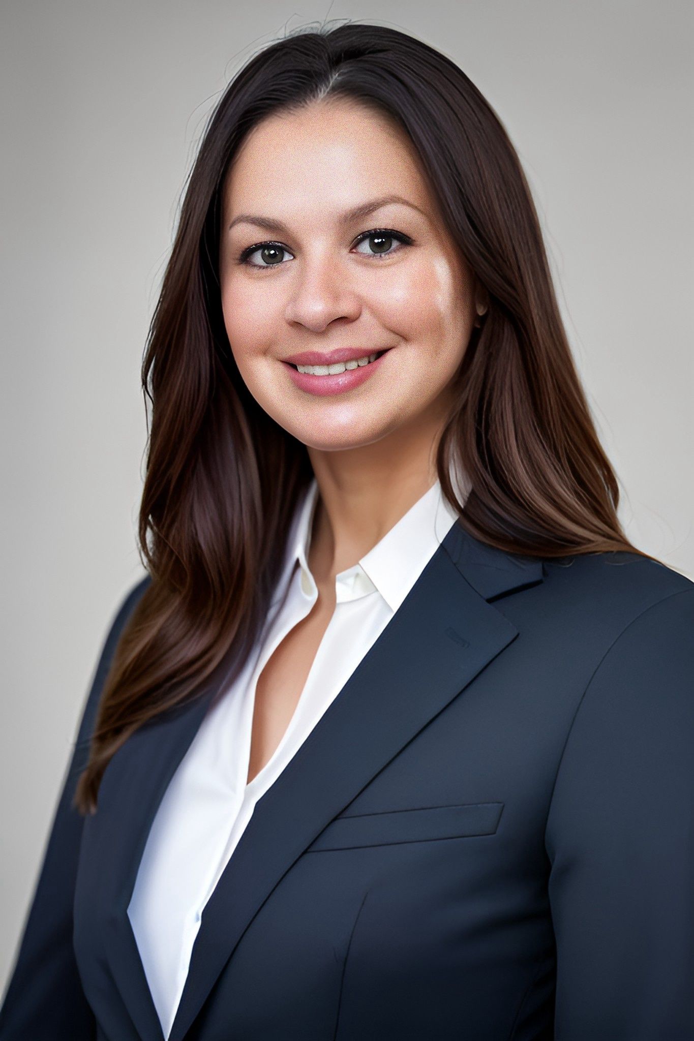 a woman in a suit and white shirt is smiling for the camera .