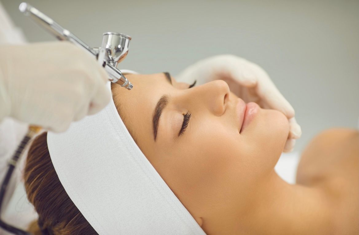 A woman is getting an oxygen treatment on her face.