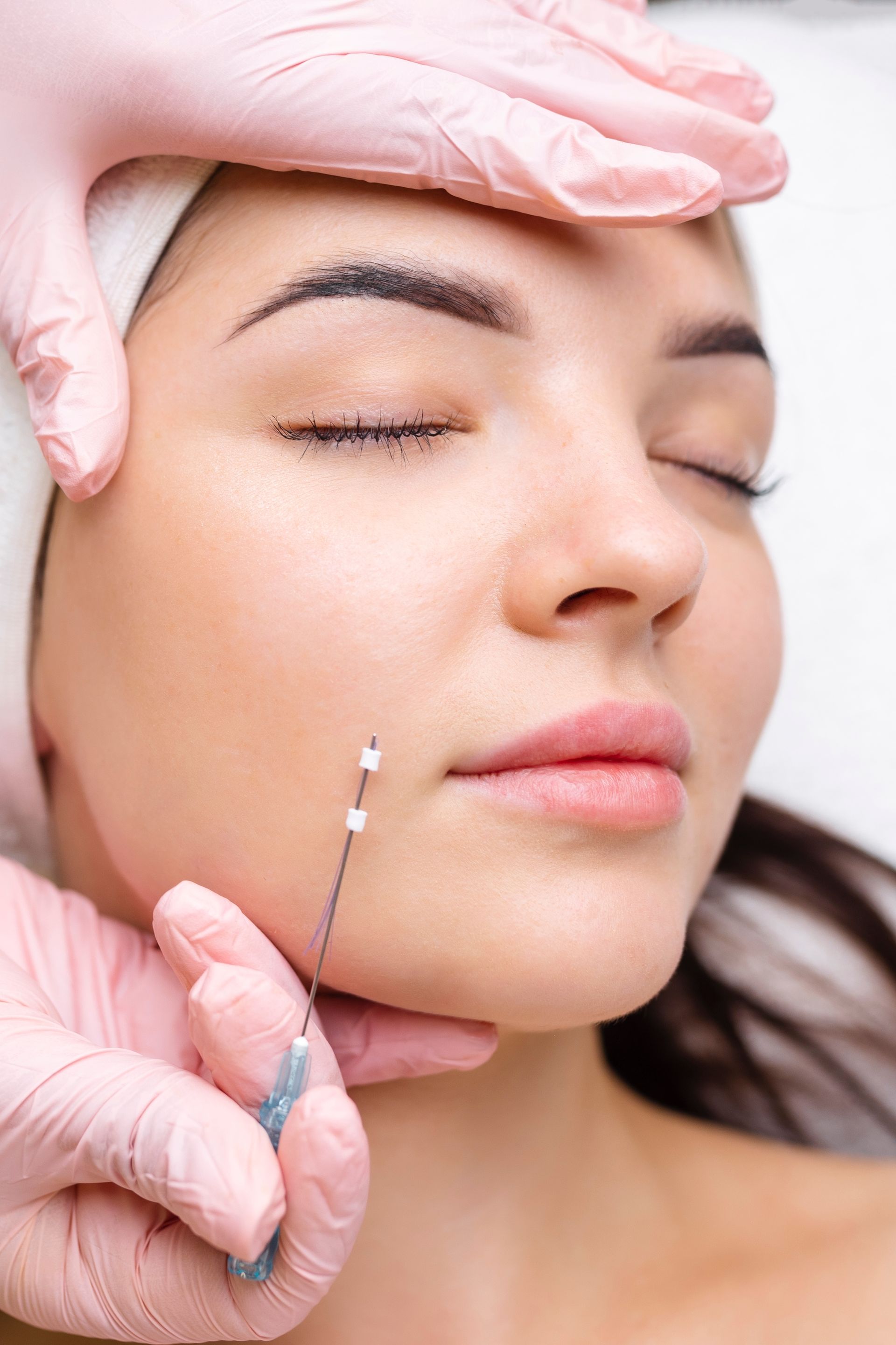 A woman is getting a botox injection in her face.