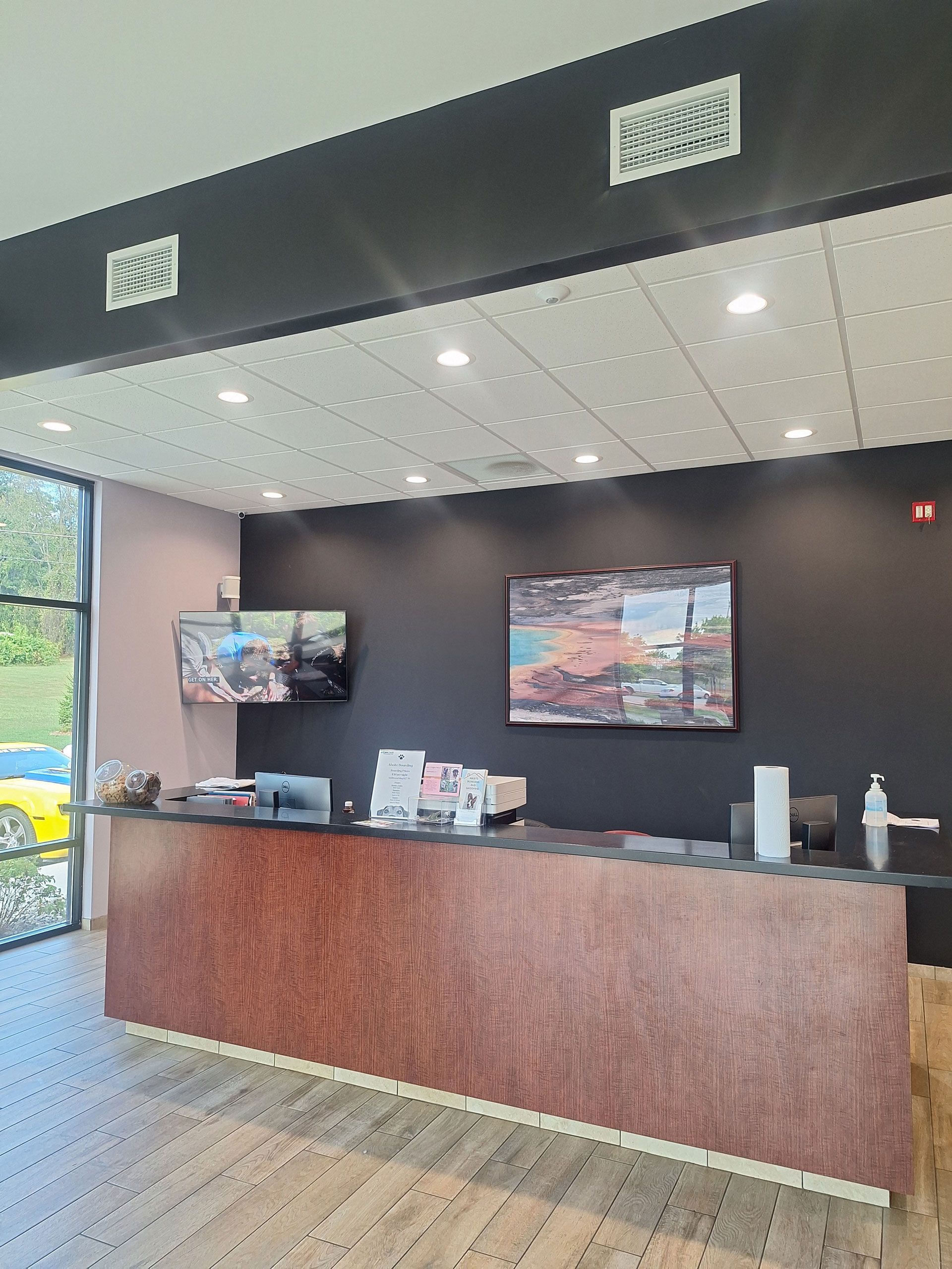 A hotel lobby with a large wooden counter and a television on the wall.