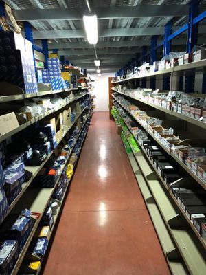 Una lunga corsia di un negozio piena di scaffali pieni di articoli.