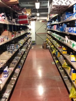 Una lunga corsia di un negozio piena di scaffali pieni di articoli.