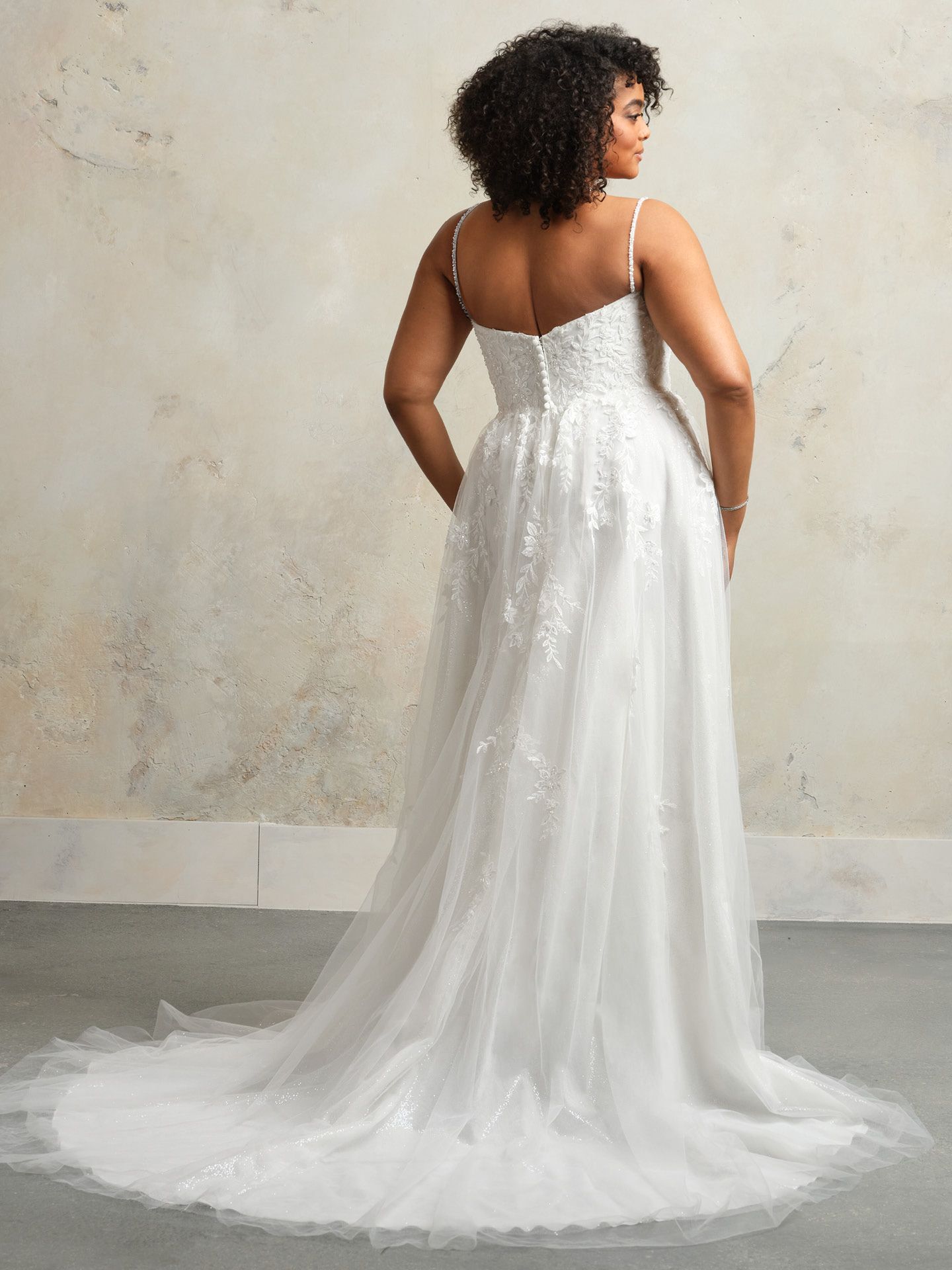A plus size woman is wearing a white wedding dress.
