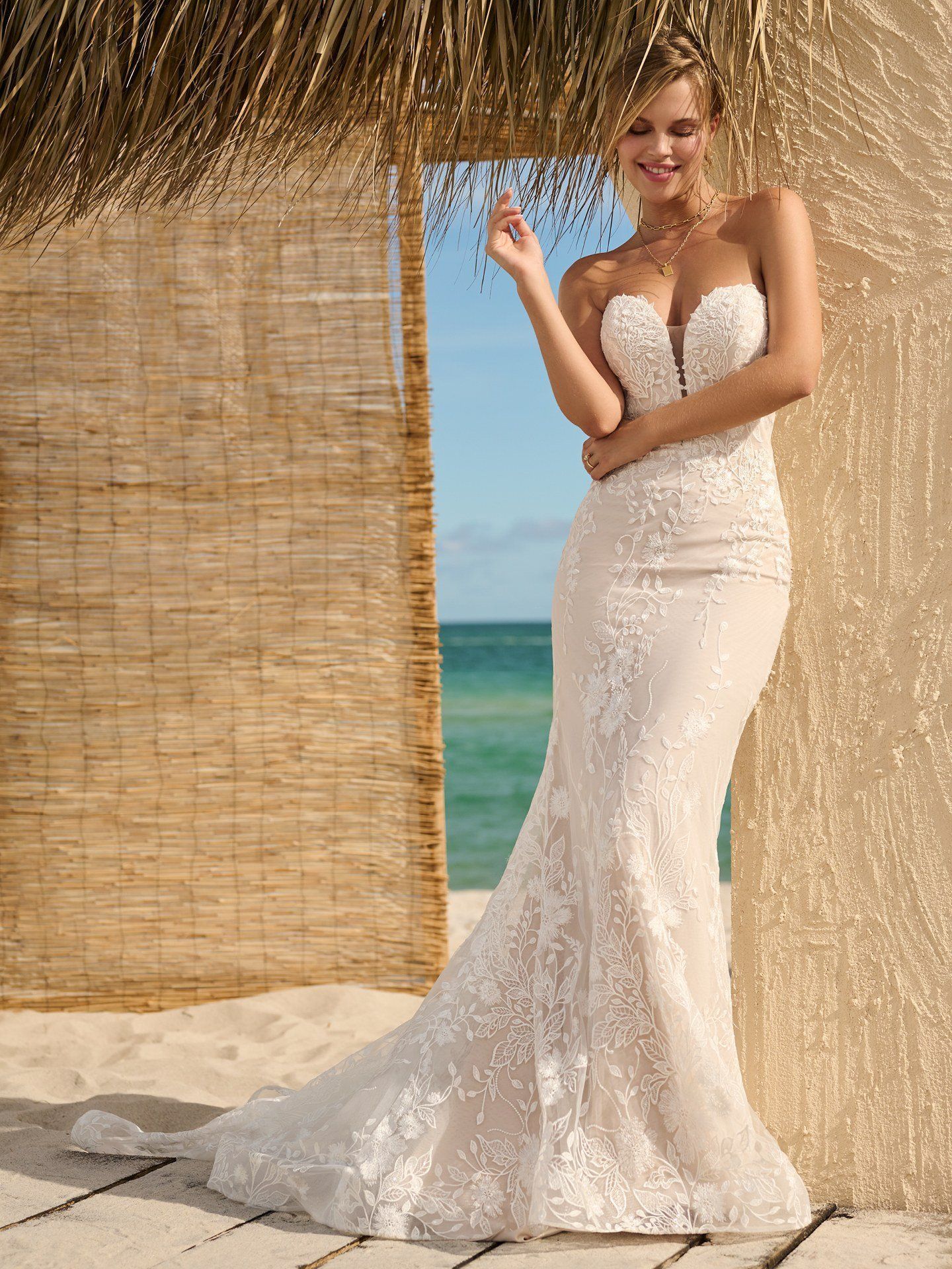A bride in a wedding dress is standing on a set of stairs holding a bouquet of flowers.