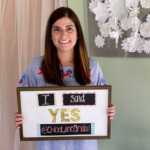 A woman is holding a sign that says i said yes