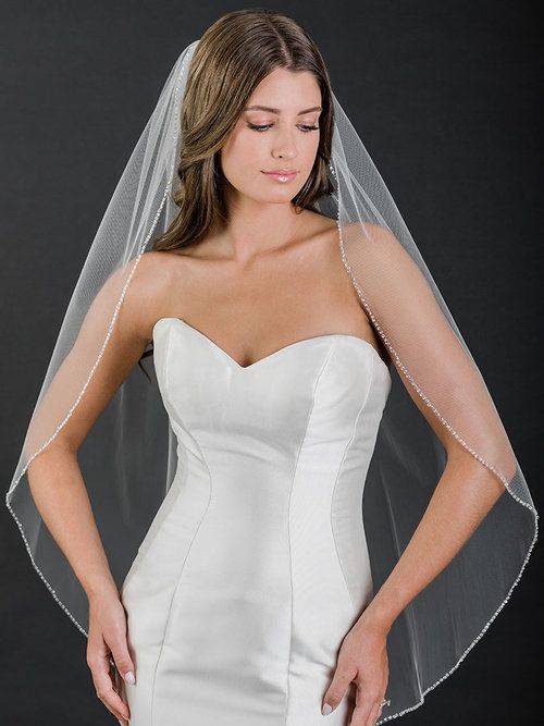 A woman in a wedding dress is wearing a veil