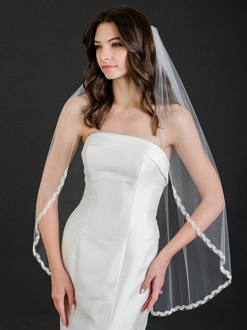 A woman in a wedding dress is wearing a veil.