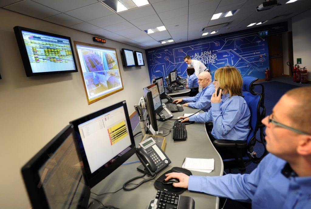 People working in a control room, monitoring computer screens. They wear blue shirts and use phones — Advanced Alarms Mackay Pty Ltd In South Mackay, QLD