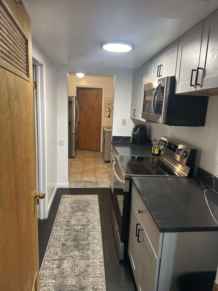 A Kitchen With Stainless Steel Appliances and Black Counter Tops