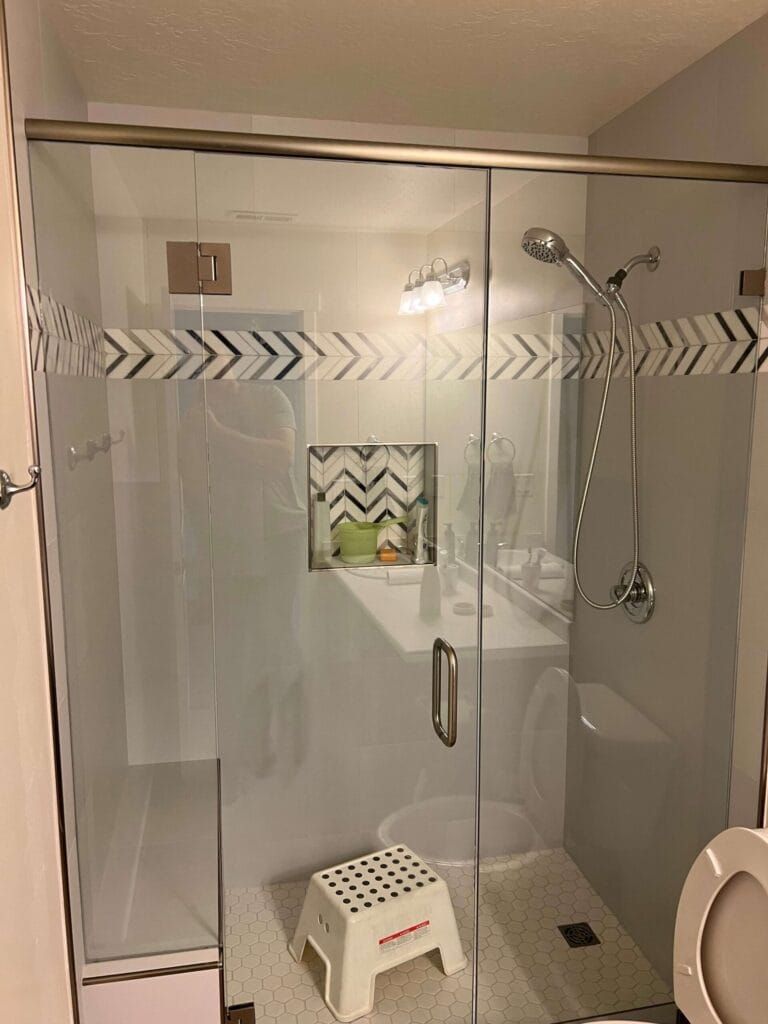 A Bathroom With a Walk in Shower , Toilet , Sink and Mirror