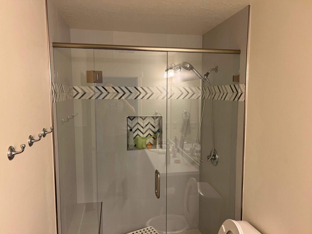 A Bathroom With a Sliding Glass Shower Door and a Toilet
