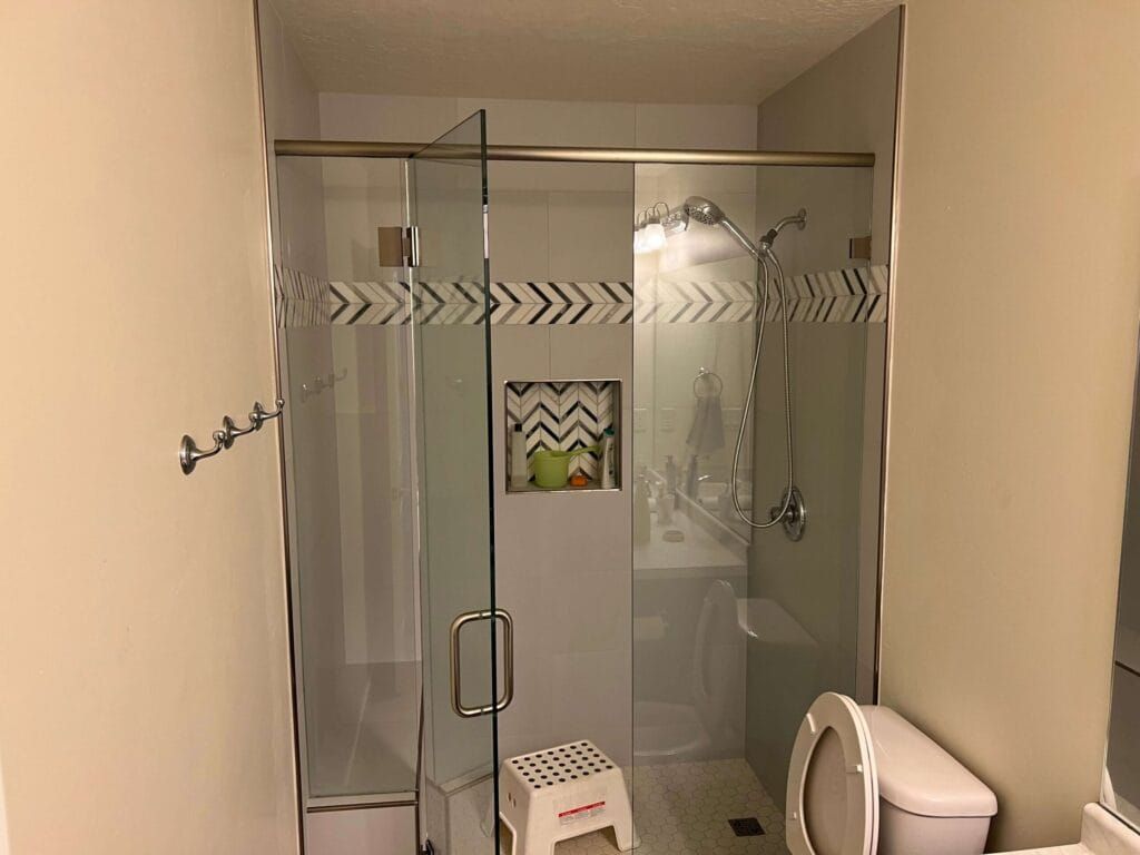 A Bathroom With a Toilet , Shower , Sink and Mirror