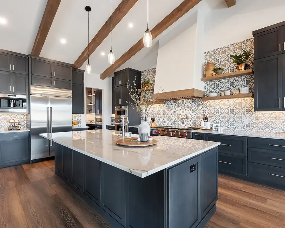 Modern kitchen with dark cabinets, marble island, wood beams, and patterned backsplash