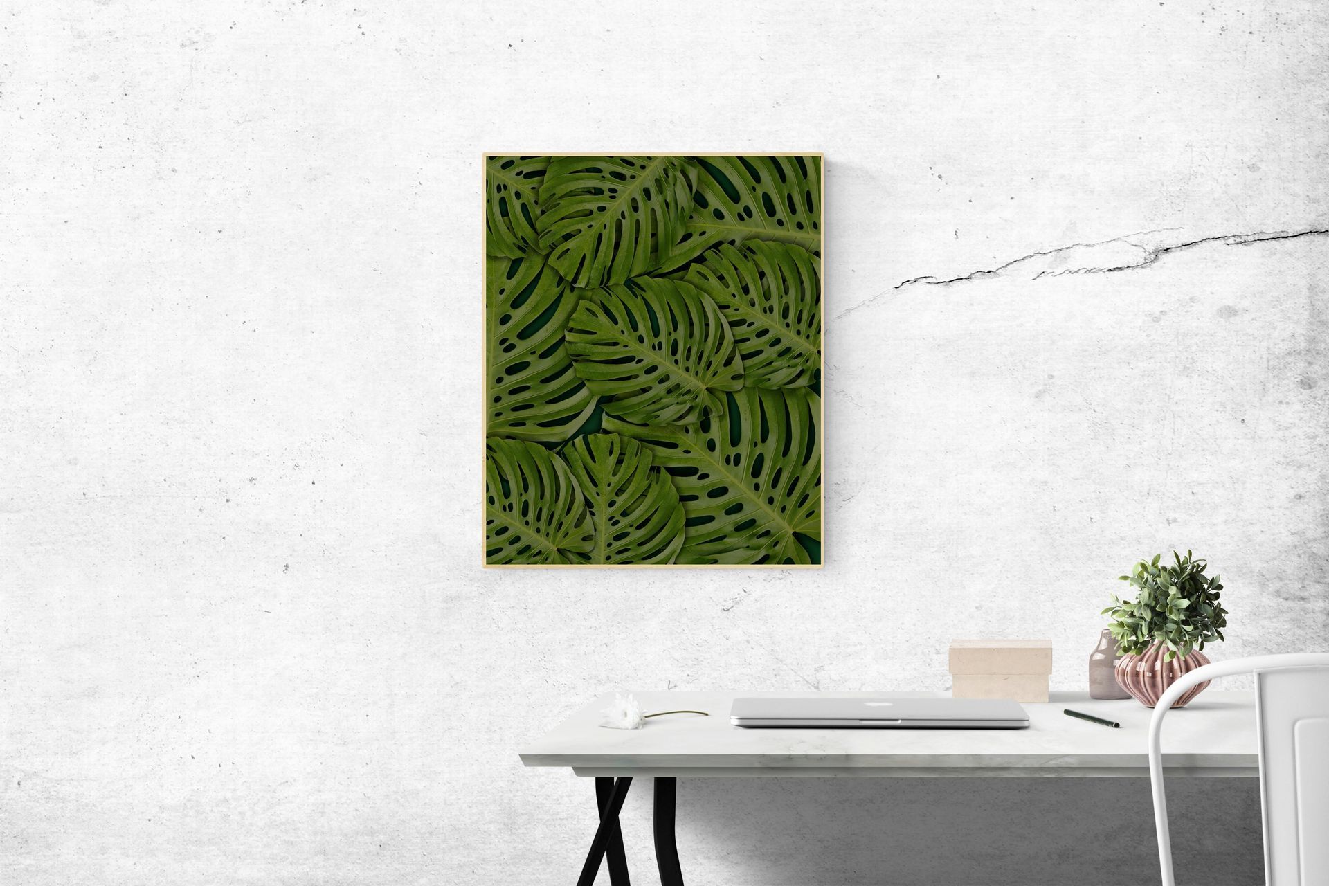 A Painting of Green Leaves Is Hanging on a Wall Above a Desk