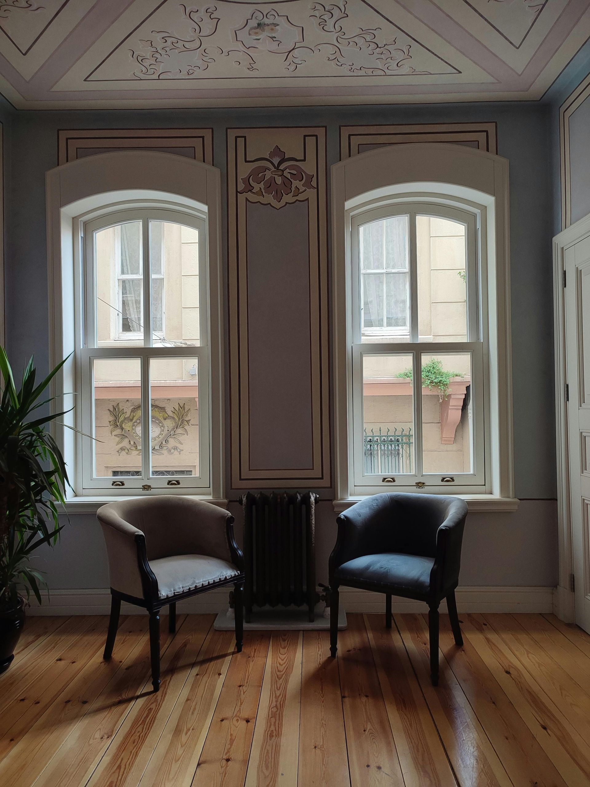 Two Chairs Are Sitting in a Room With Lots of Windows