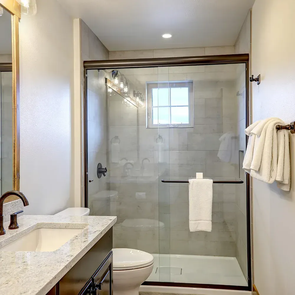 Modern bathroom with white vanity, bathtub, and large mirror. Neutral tones, good lighting.