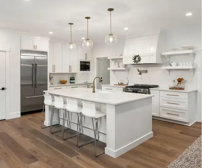 Bright modern white kitchen with island, bar stools, stainless appliances, and wood floors