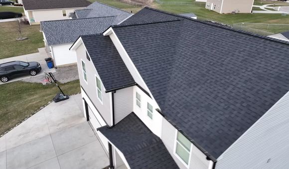 An aerial view of a house with a black roof.