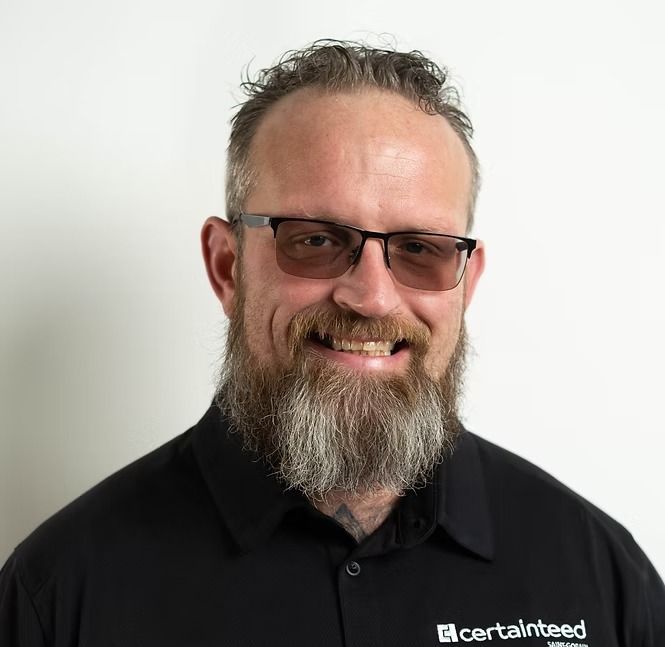 A man with a beard and glasses is smiling for the camera.