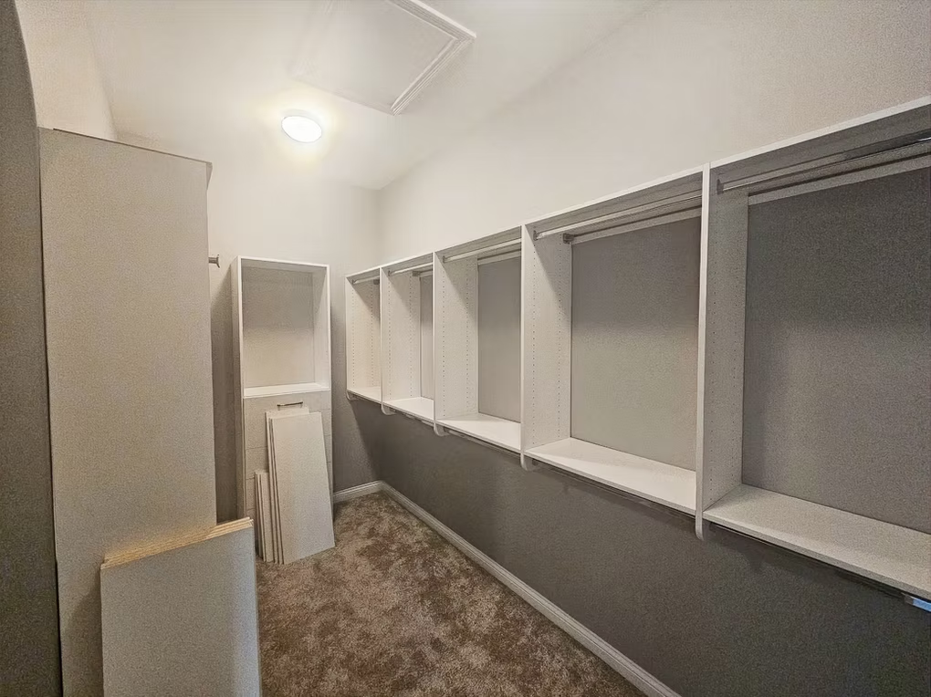 A walk in closet with lots of shelves and a ladder.