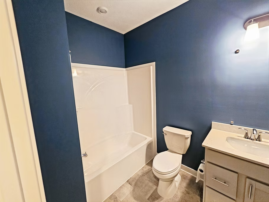 A bathroom with a toilet , sink and bathtub.