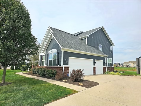 A large house with a garage and a driveway in a residential area.
