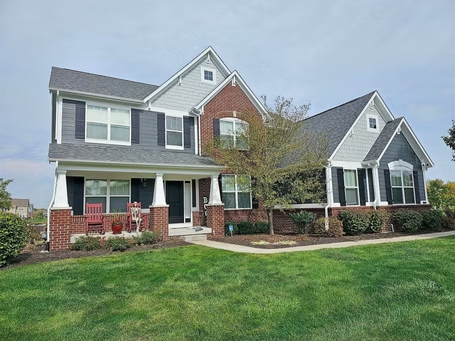 A large house with a lush green lawn in front of it.