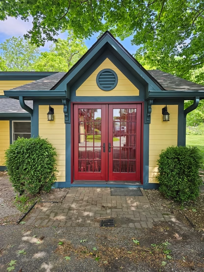 A yellow and blue house with a red door