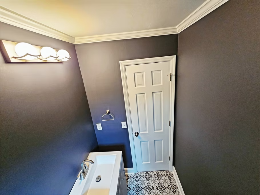 A bathroom with a sink and a door.