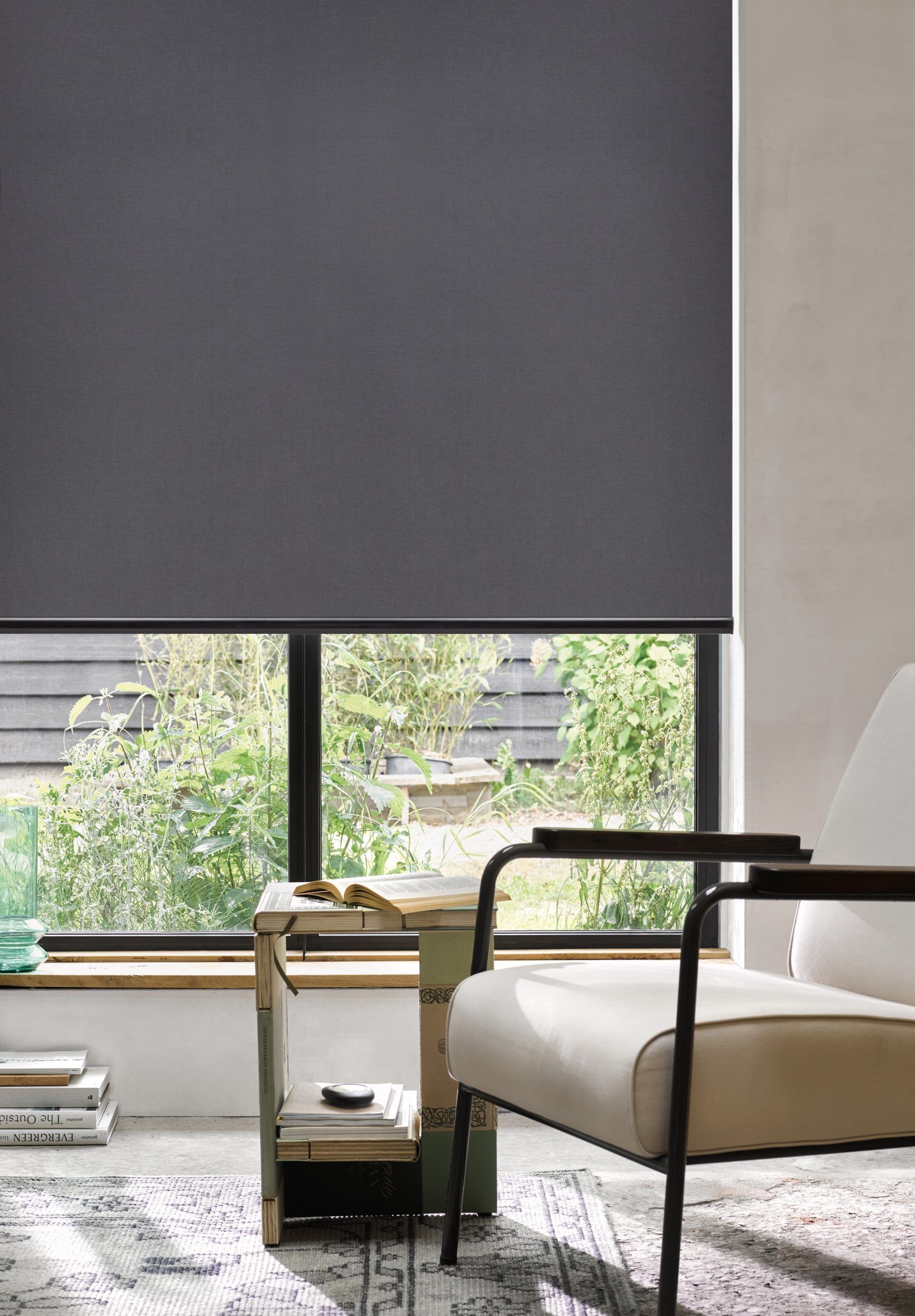 A living room with a chair and a window with a gray blind.