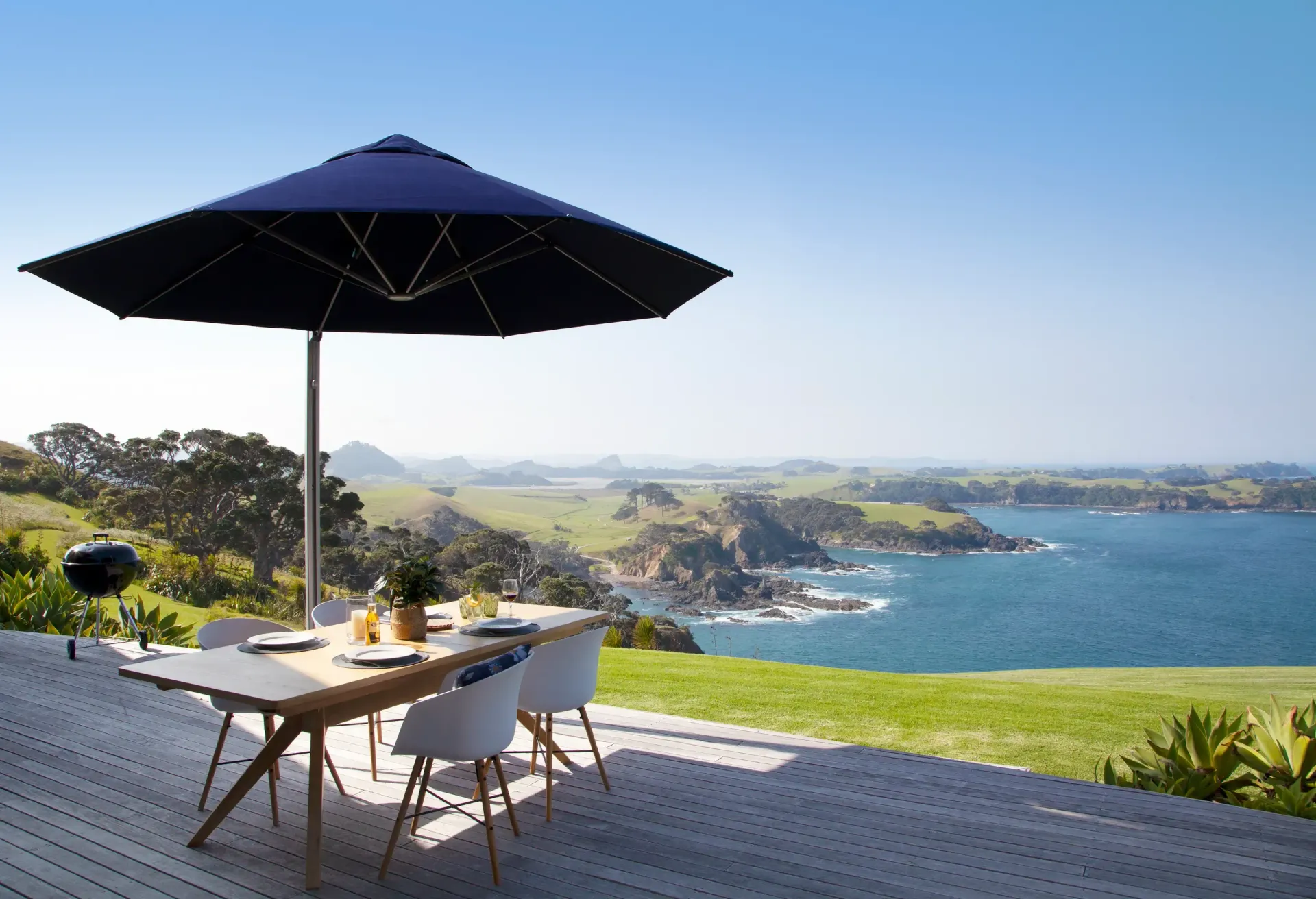 Modern backyard with a retractable awning over a patio dining area, providing shade by the poolside.