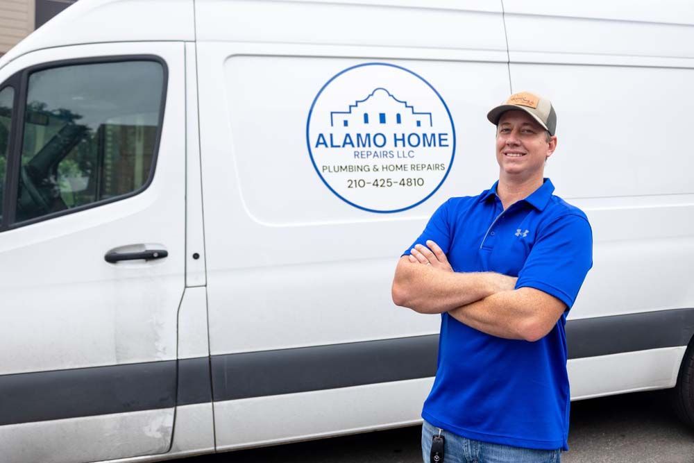 A man in a blue shirt is standing in front of a white van.
