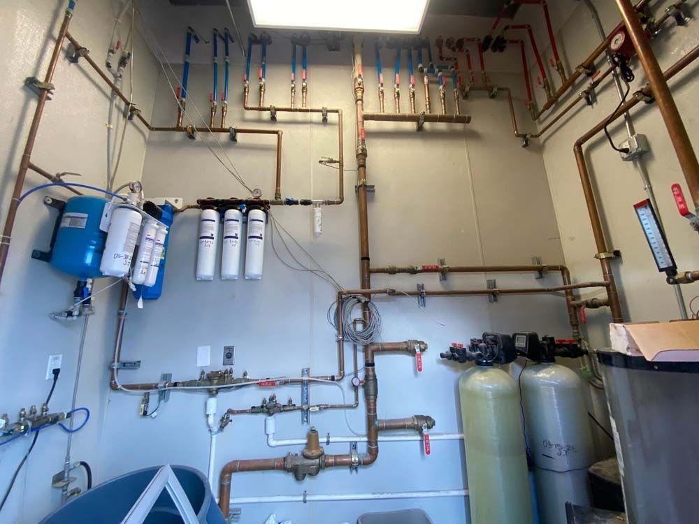 A room with a lot of pipes hanging from the ceiling