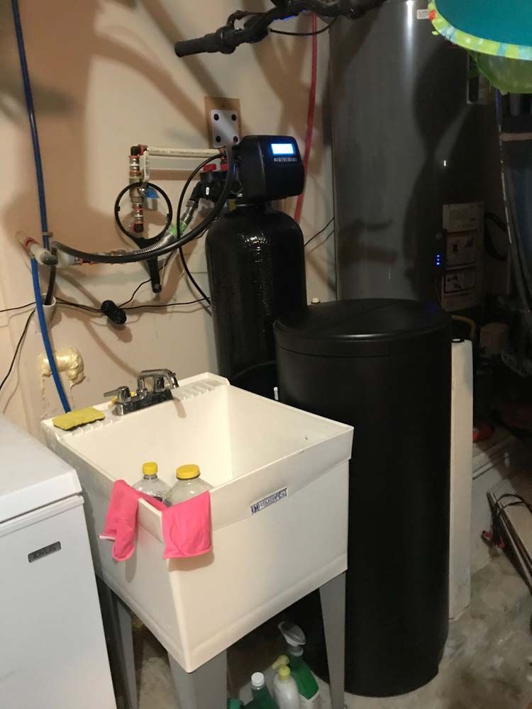 A laundry room with a sink and a water heater