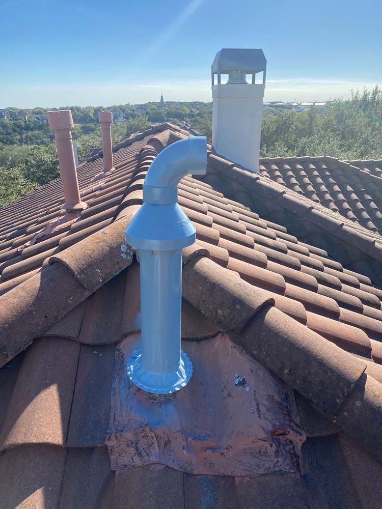 A chimney is sitting on top of a tiled roof.