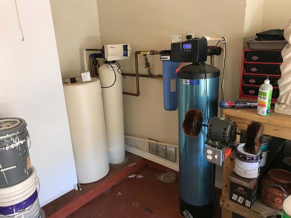 A room with a water heater and a water filter.